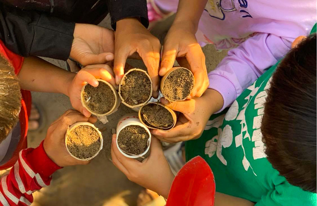 children holding small seeds